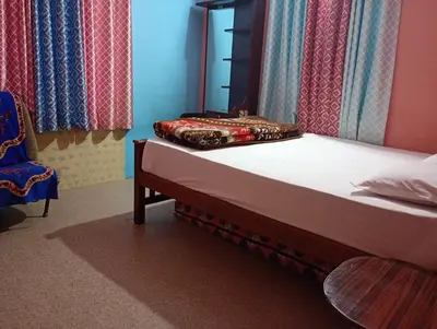 a bedroom with a bed with a mirror and a chair at Enjoy home stay in Vattavada
