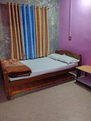 a bed sitting in a room with a curtain at Enjoy home stay in Vattavada