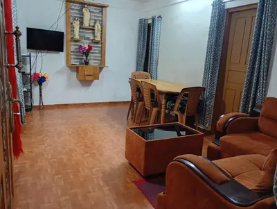 a living room with a table and chairs at Enjoy home stay in Vattavada