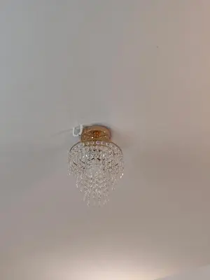 a chandelier hanging from the ceiling of a room at Ivory Suites in Kozhikode