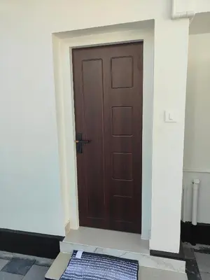a wooden door with a mat in front of it at Ivory Suites in Kozhikode