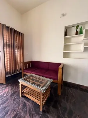 a living room with a red couch and a table at AP'S Homestay Nilambur in Nilambūr