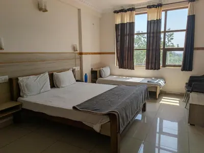 a bedroom with two beds and a window at Pegasus Home in Coimbatore