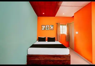 a bedroom with orange walls and a bed in it at Aryas comforts Sri Rangapattana in Nāganahalli