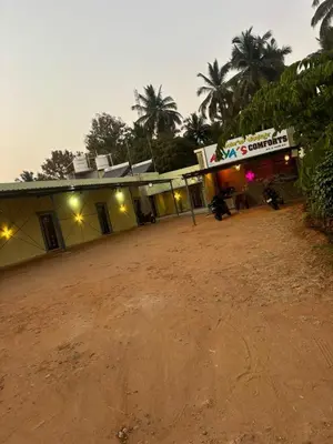 a dirt road in front of a building at Aryas comforts Sri Rangapattana in Nāganahalli