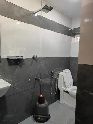 a bathroom with a shower and a toilet and a sink at Ivory Suites County in Kozhikode