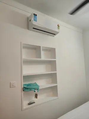a shelf in a room with a white wall at Ivory Suites County in Kozhikode