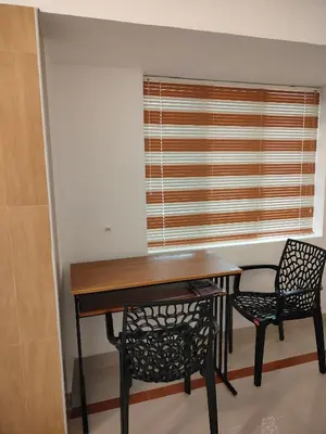 a dining room table with two chairs and a window at Ivory Suites County in Kozhikode