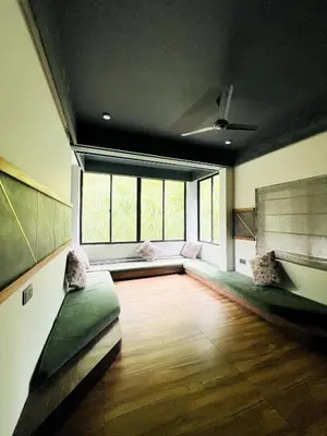 a large room with two couches and a large window at oakden lakkidi villa vythiri villa wayanad in Vythiri