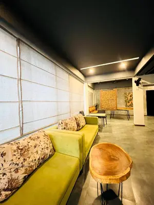 a living room with a yellow couch and a table at oakden lakkidi villa vythiri villa wayanad in Vythiri