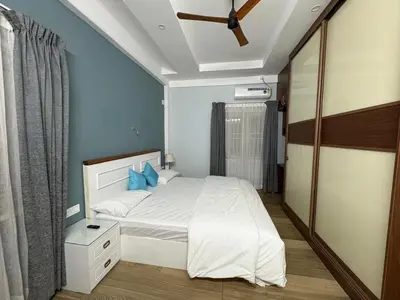a bedroom with a bed with blue walls and a ceiling at Evania Pool Suites in Nedumbassery