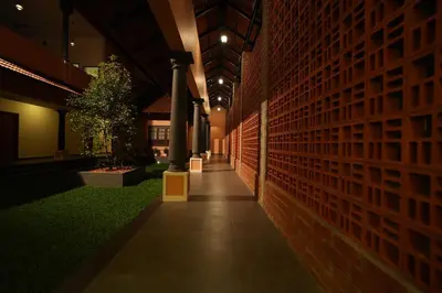 a hallway of a building with a brick wall at Vaigayi Ayurveda Resort in Kodanad
