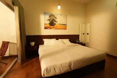 a bedroom with a large white bed in a room at Vaigayi Ayurveda Resort in Kodanad