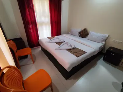 a bedroom with a bed with two towels on it at RajPari Stay in Madikeri