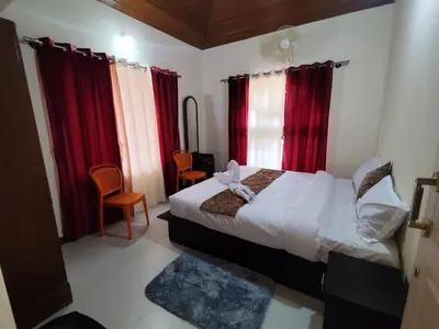 a bedroom with a bed and red curtains at RajPari Stay in Madikeri