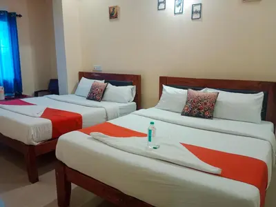 two beds in a hotel room withacers at G S Rooms Mysore in Mysore