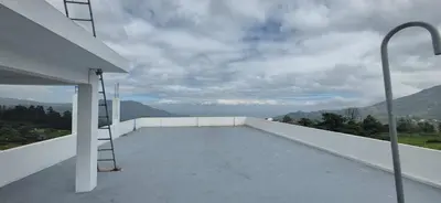 a white balcony with a ladder on the roof at IndivaStays - Sixface Park in Ooty