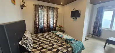 a bedroom with a bed and a television in it at IndivaStays - Sixface Park in Ooty