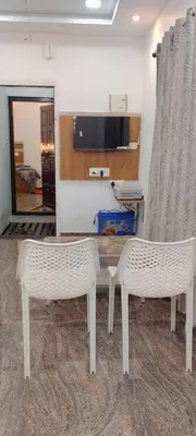 two white chairs and a table in a room at Thendral Stay Marayoor in Marayoor