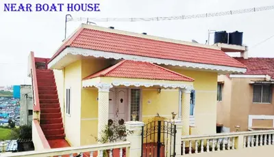 a small yellow house with a red roof at Arnold Home Stay Ooty in Ooty