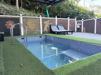 a small swimming pool with a bench next to a fence at Aditi By Greenleaves Resort Vythiri in Vythiri
