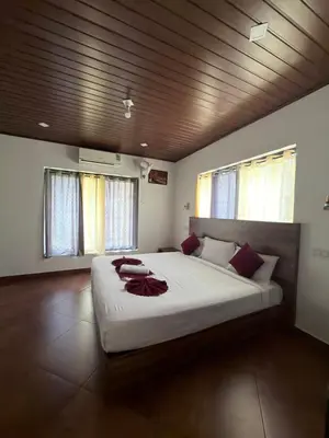 a bedroom with a large bed with a wooden ceiling at Aditi By Greenleaves Resort Vythiri in Vythiri