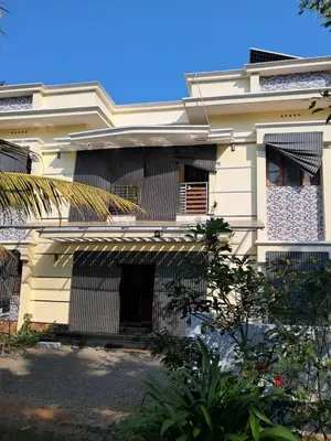 a white house with an awning in front of it at Vilasini Nivas in Irinjālakuda