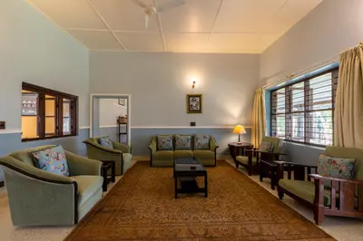 a living room with couches and a table at amã Stays & Trails - Woshully Bungalow, Coorg in Gonikoppal