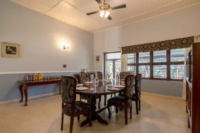 a dining room with a table and chairs at amã Stays & Trails - Woshully Bungalow, Coorg in Gonikoppal