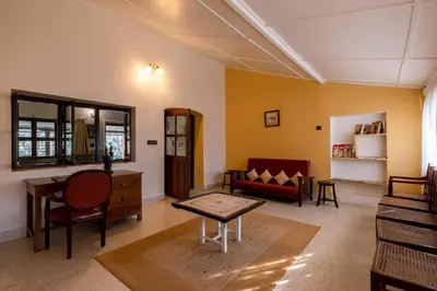 a living room with a couch and a table at amã Stays & Trails - Woshully Bungalow, Coorg in Gonikoppal