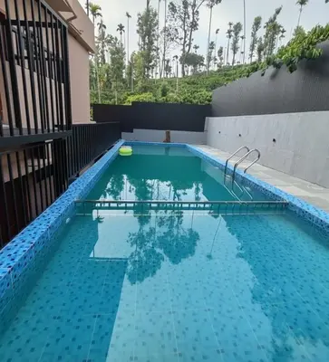 a swimming pool with a frisbee in the water at Elnido Holiday Home in Meppādi