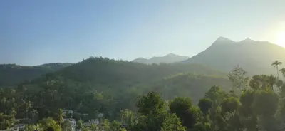 a view of a valley with mountains and trees at Elnido Holiday Home in Meppādi