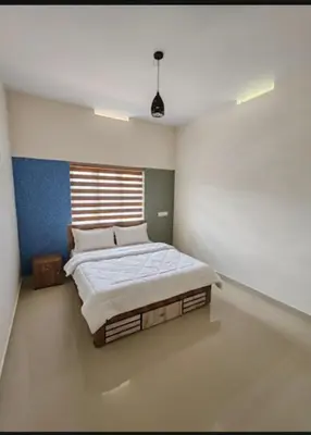 a bedroom with a large bed in a room at Elnido Holiday Home in Meppādi