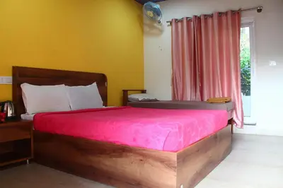 a bedroom with a wooden bed with a red blanket at Aranya Cottage Coorg in Suntikoppa
