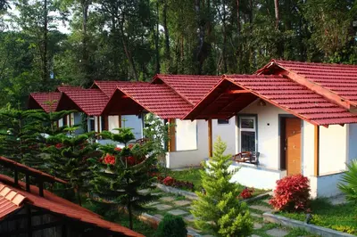 a row of cottages with red roof at Aranya Cottage Coorg in Suntikoppa