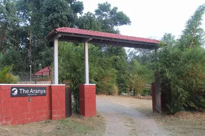 a gate in a brick wall with a sign on it at Aranya Cottage Coorg in Suntikoppa