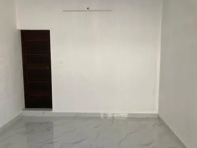 a room with a white wall and a door at V-host in Alwaye