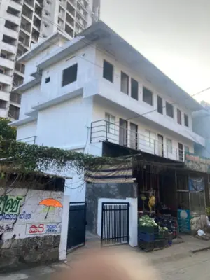 a white building with an umbrella in front of it at V-host in Alwaye