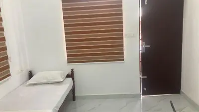 a small room with a bed and a window at V-host in Alwaye