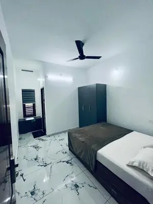 a bedroom with a bed and a ceiling fan at Stay loop in Cherambādi