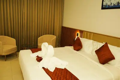 a hotel room with two beds with white sheets at Dwaraka INN