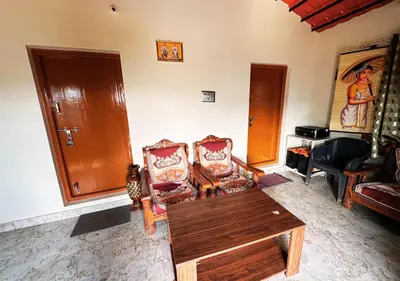 a living room with two chairs and a table at Sol Malai Retreat near MM Hills by Travent Mug