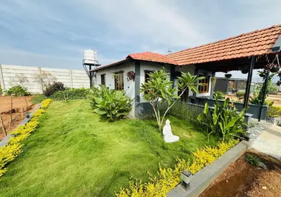 a house with a grass yard with a white object on it at Sol Malai Retreat near MM Hills by Travent Mug