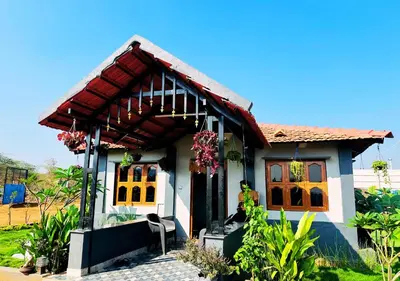 a small white house with a red roof at Sol Malai Retreat near MM Hills by Travent Mug