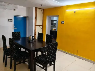 a dining room with a black table and chairs at White House Resort in Ooty
