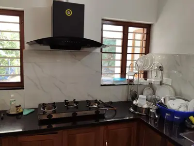 a kitchen with a stove and a counter top at Mellow Villa cochin airport in Angamali