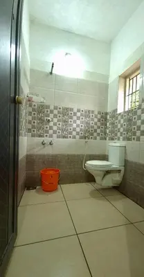 a bathroom with a toilet and a shower at Clement homes in Kalpetta