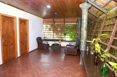 a living room with a wooden floor and a large window at Clement homes in Kalpetta