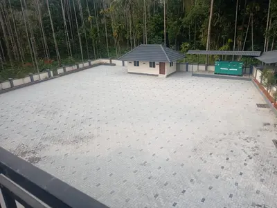 a large concrete patio with a small house on it at PURAYIL Rooms in Kozhikode