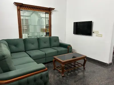 a living room with a green couch and a coffee table at Entire 4BHK House with Full Kitchen near malayattoor in Kodanad